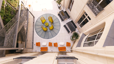 Vogelperspektive eines Innenhofs mit Sitzgelegenheiten in Orange und Gelb