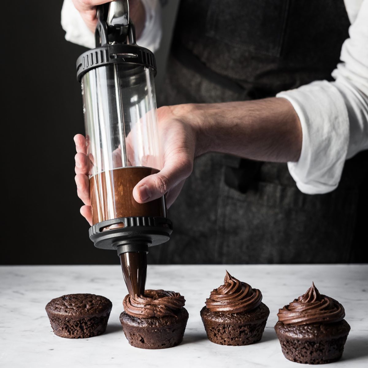 Person preparing piped biscuits with “Le Tube” pastry syringe