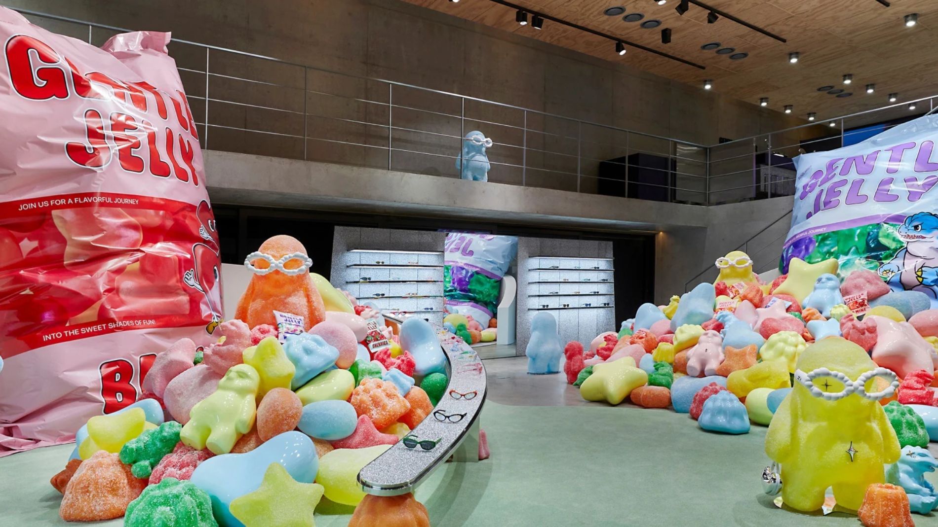 Colourful art exhibition featuring oversized candy sculptures and giant jelly packaging in a modern gallery space.