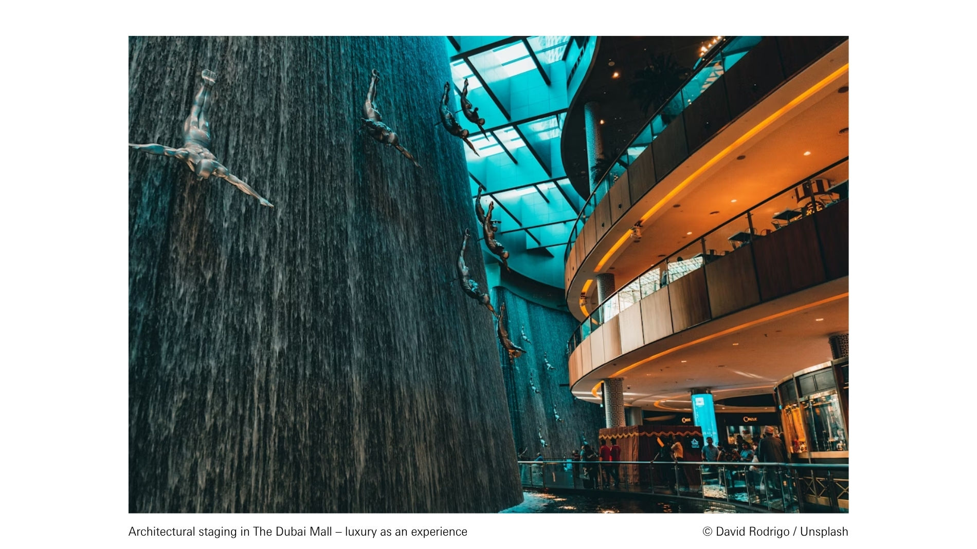 Architectural staging in The Dubai Mall featuring a waterfall and sculptures, symbolising luxury as an immersive experience.