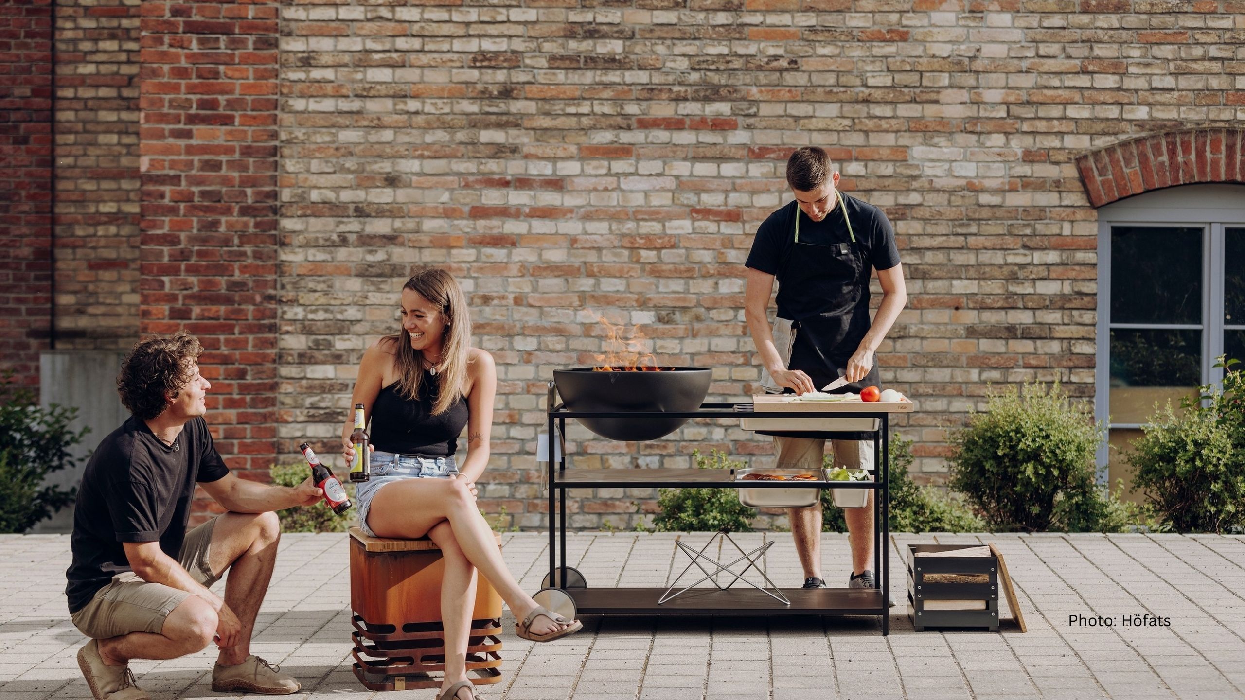 Man stands at a barbecue and cuts vegetables