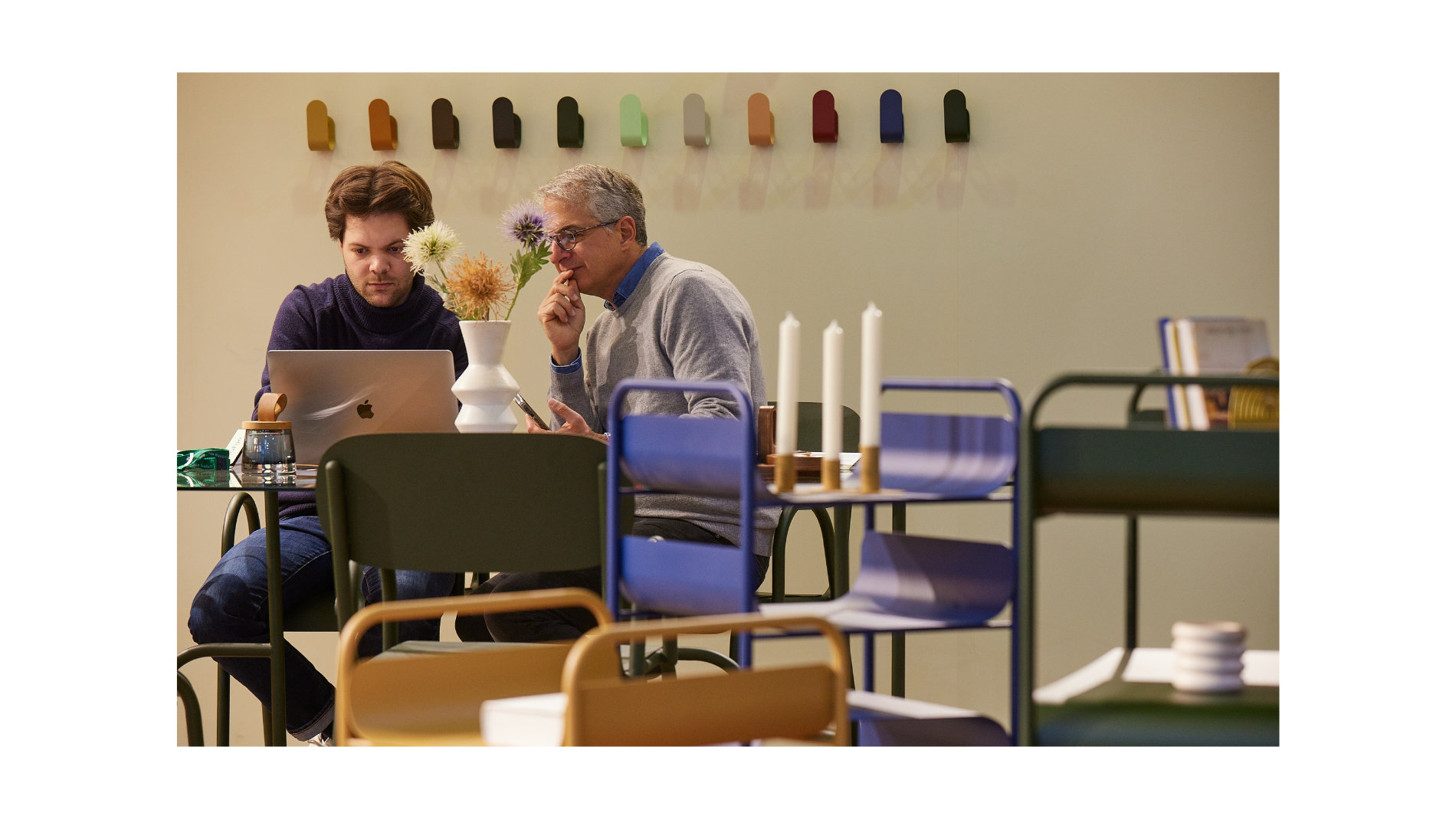 Zwei Männer vor einem Laptop in einem Café
