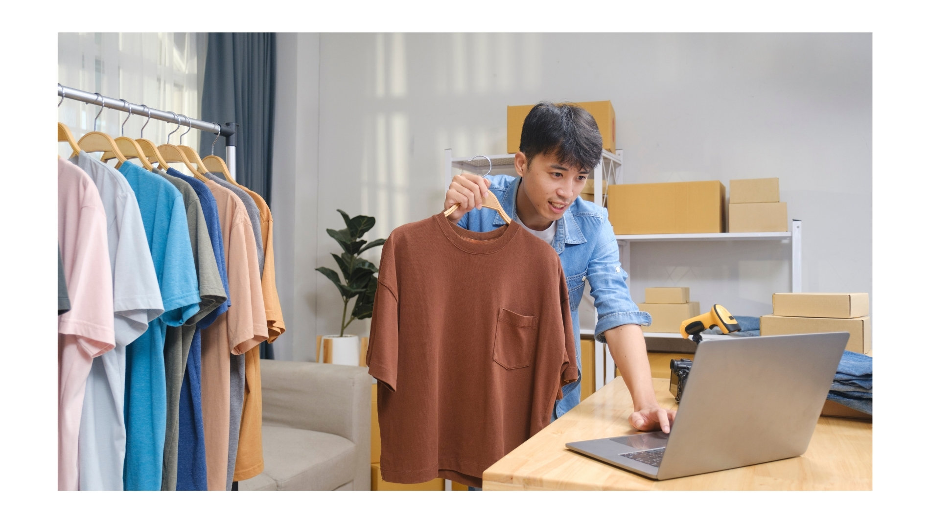 Mann präsentiert ein braunes T-Shirt zu einem Laptop
