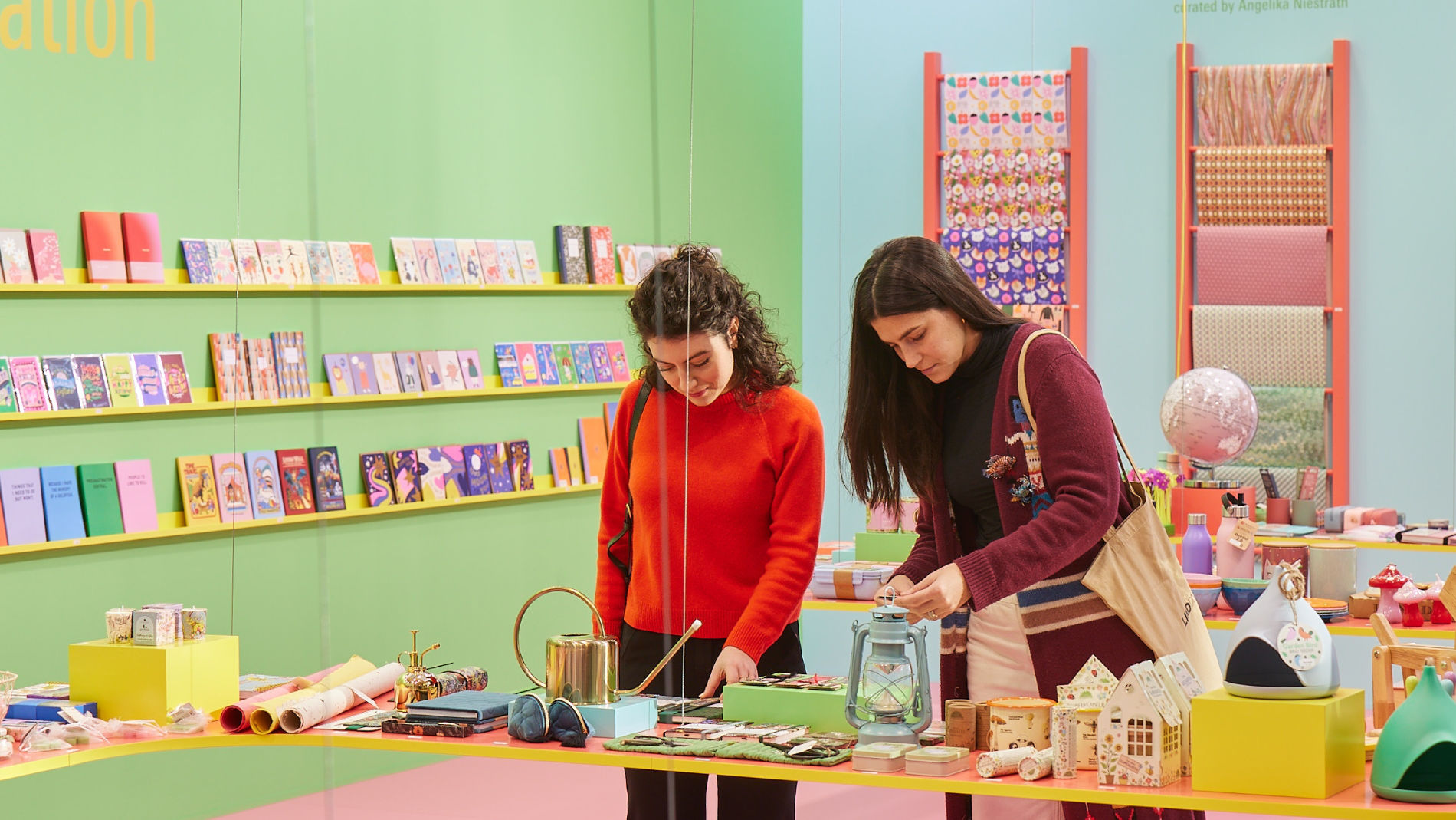 Zwei Frauen betrachten Bücher in einem Messestand