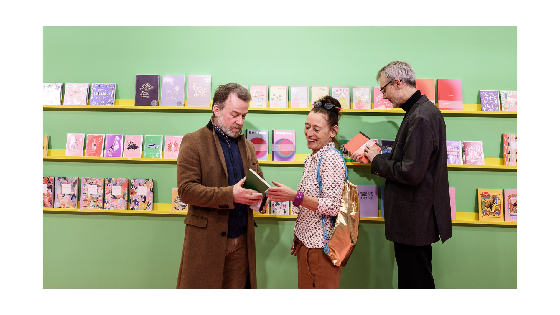 Drei Personen vor einem Bücherregal