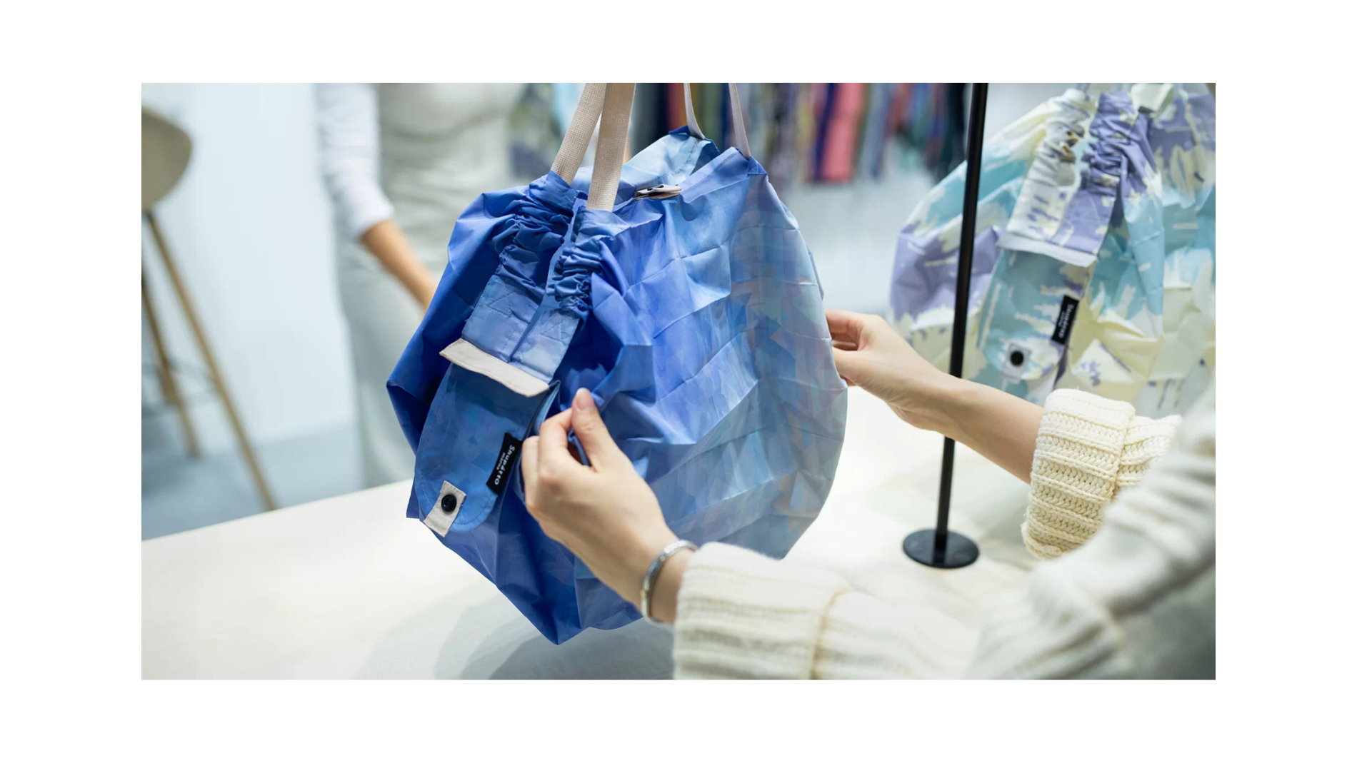 Hands holding a blue bag