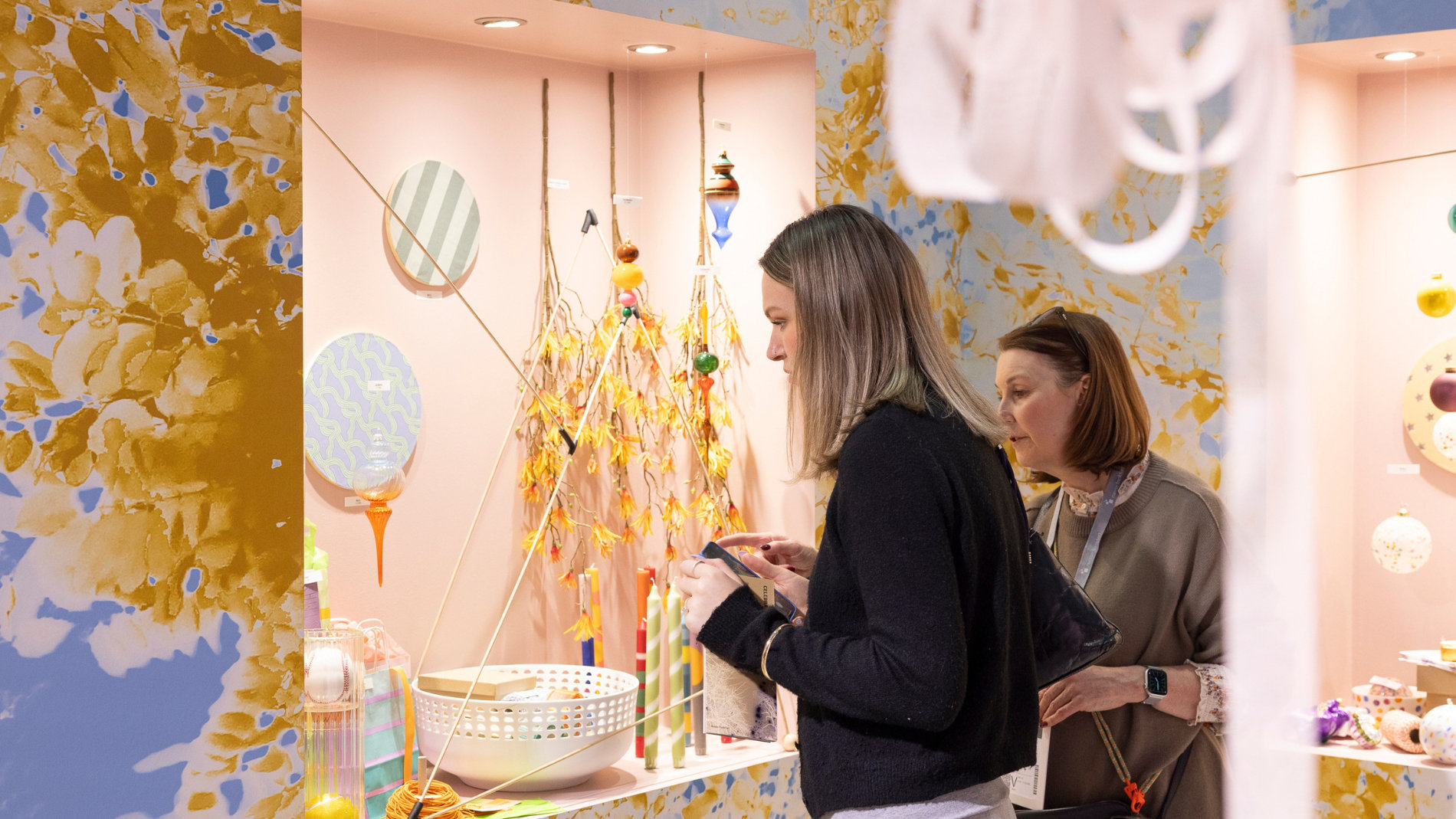 Zwei Frauen vor einem Messestand zu Schaufensterdeko