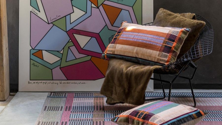 Designstuhl mit Kissen, Decke und Teppich