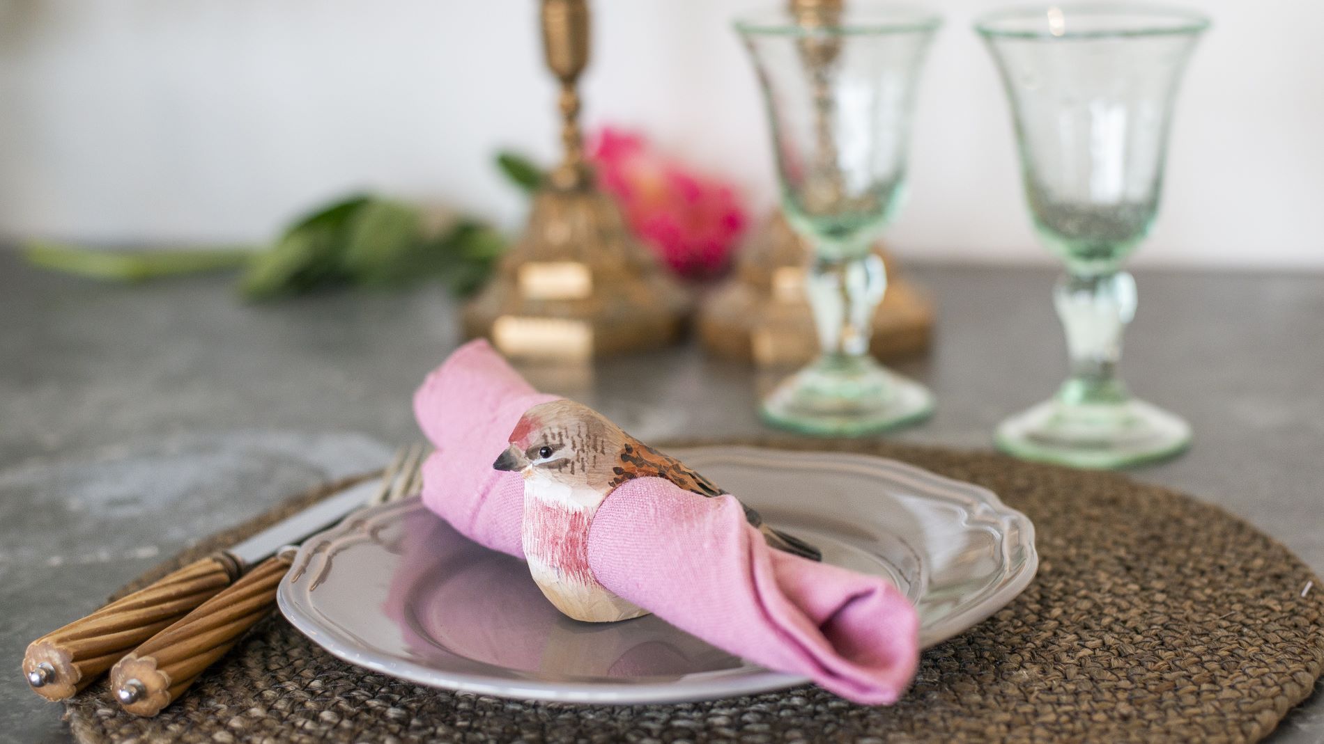 Frühlingshafte Tischdekoration mit rosa Serviette und Vogel-Serviettenring