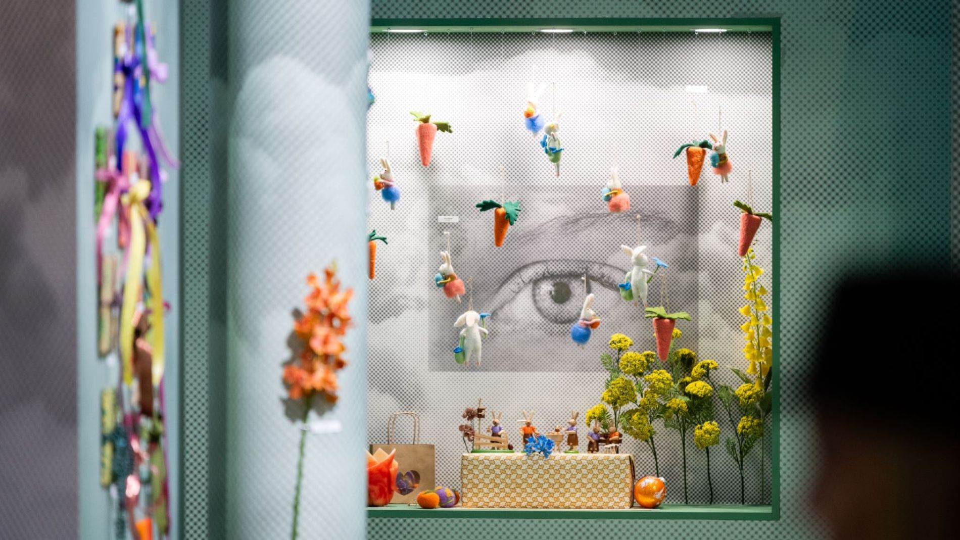 Verspieltes Schaufenster mit hängenden Karotten und kleinen Hasenfiguren