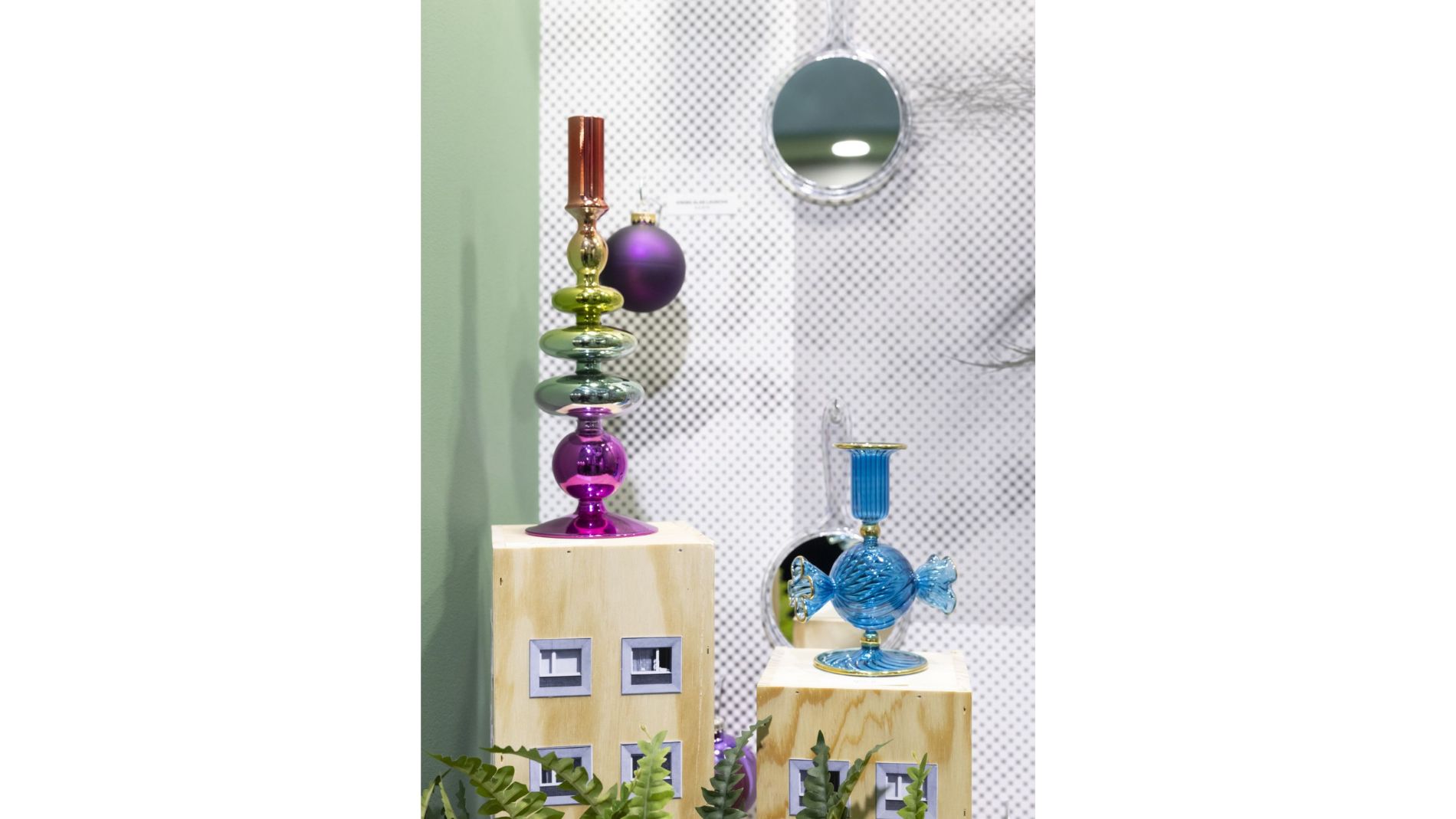 Schaufenster mit bunten Glasobjekten auf Holzpodesten